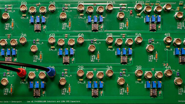 Nahaufnahme einer Platine mit elektrischen Schaltungen, Bauteilen und LEDs für topolektrische Forschung.